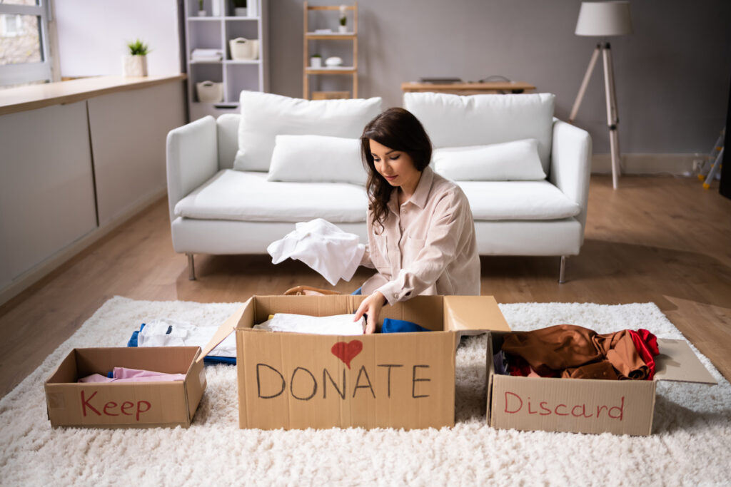 National Get Organized Month. Woman going through belongings for donation, keep or discard.