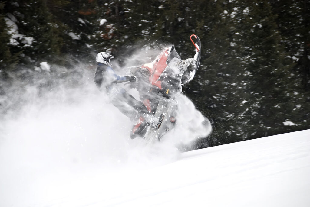 Snowmobiler jumping his snowmobile in extreme powder on a mountain in Idaho.