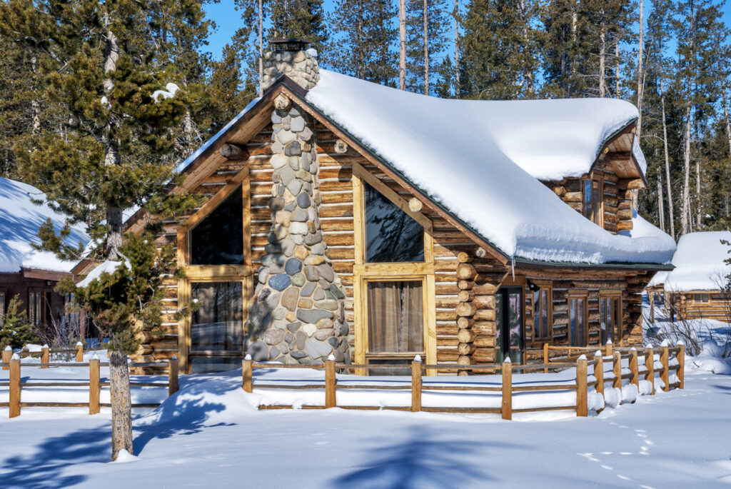 Idaho Log cabin and fence with a fence around it in the woods