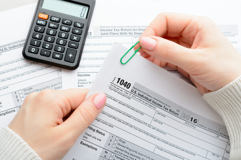 A woman sitting at a table and holds a tax form