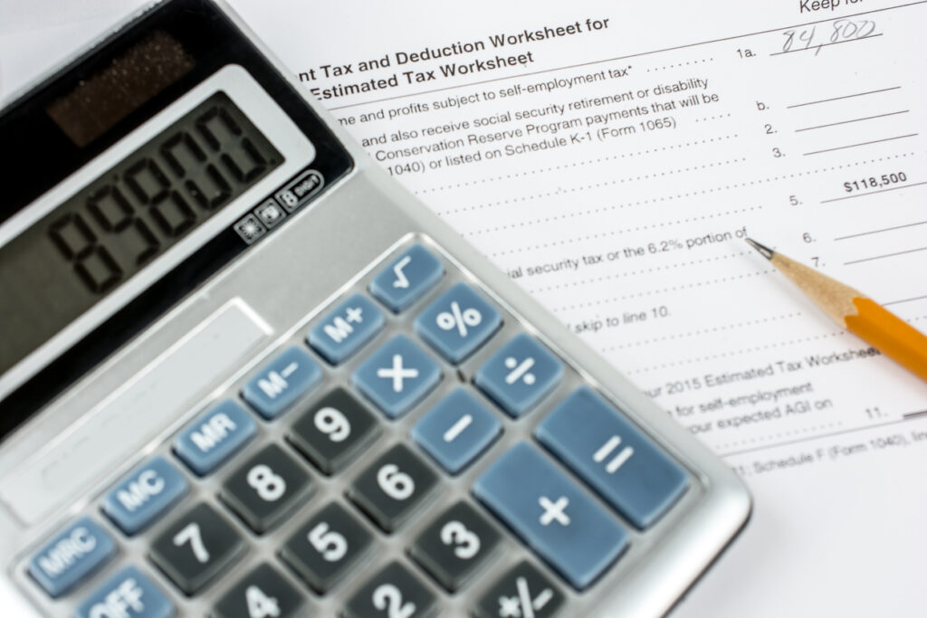 Close-up of a United States tax deuction worksheet. Shown with a pencil and calculator.