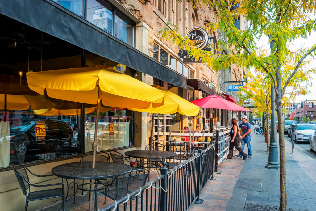 People dine at a restaurant patio in downtown Boise Idaho USA in the evening.
